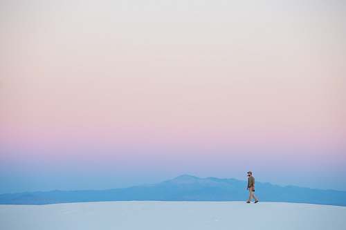 white sands human walking on snow covered mountain minimal